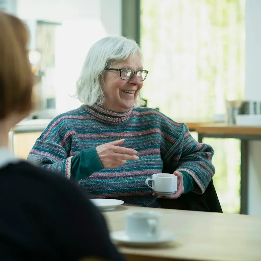 Woman talking with a friend across a café table