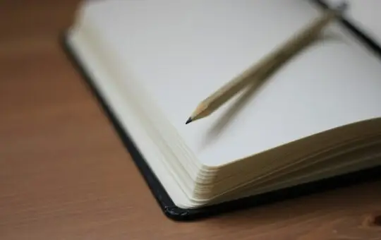 Pencil resting on an open notebook